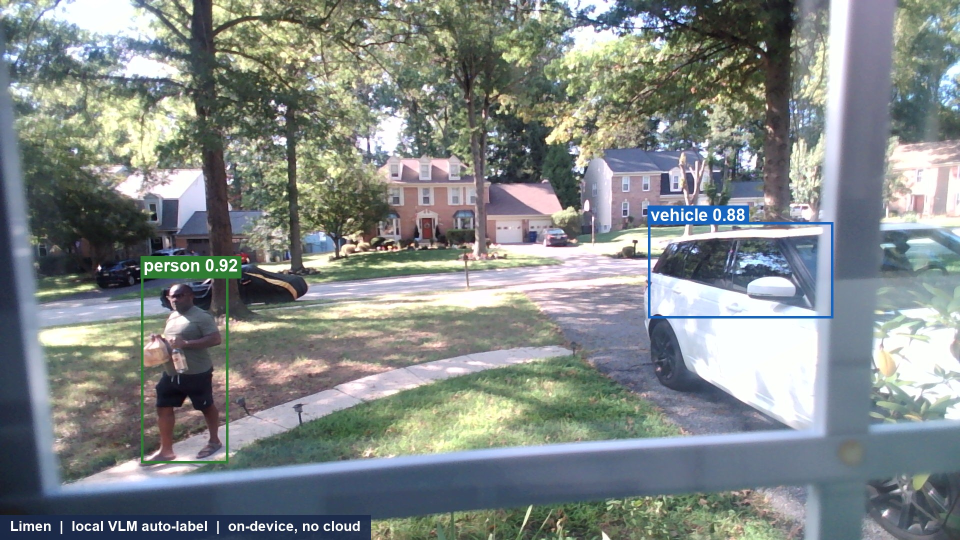 A view from a front window: a man walking up the path toward the door holding a bag and a bottle, boxed on device with a green person label, with his vehicle boxed and a blue vehicle label, and a caption reading Limen local VLM auto-label on-device no cloud